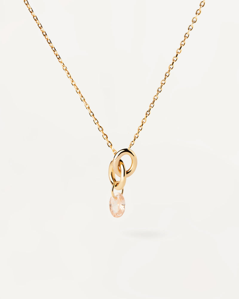 Gold-plated necklace featuring two interlinked rings with a peach zirconia drop pendant