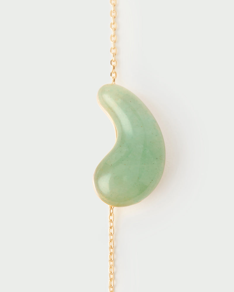 Gold-plated chain necklace with a green gemstone fluid drop