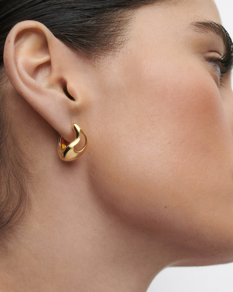 Gold-plated sculptural hoop earrings with an asymmetric drop design