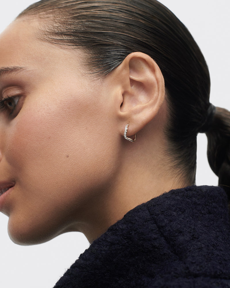Fluid half eternity hoops featuring an undulating row of round lab-grown diamonds